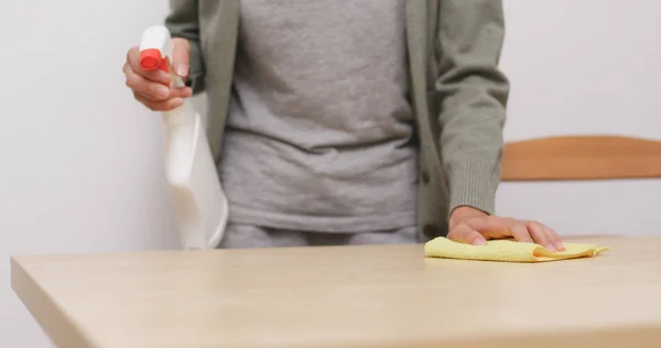 Ama de casa limpiando una mesa — Foto de Stock