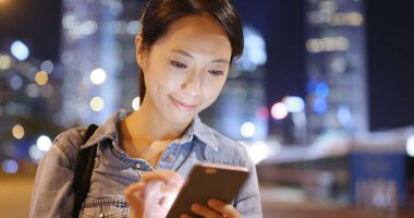 Smartphone şehirde geceleri kullanan kadın 