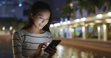 Cep telefonu şehirde geceleri kullanan kadın