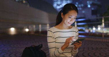 cep telefonuyla şehirde gece kadın