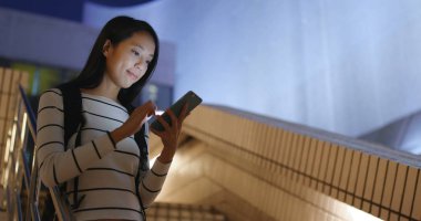 Cep telefonu şehirde geceleri kullanan kadın