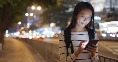 Akıllı telefon kullanan genç bir kadın.