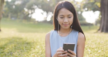 Parkta cep telefonu kullanan bir kadın. 