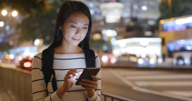 cep telefonuyla şehirde gece kadın