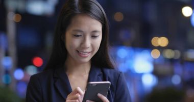 Geceleri cep telefonu kullanarak iş kadını