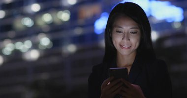 İşkadını Smartphone şehirde geceleri kullanarak.