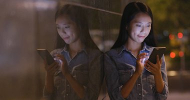 Cep telefonu şehirde geceleri kullanan kadın