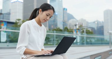 Açık, dizüstü bilgisayar üzerinde çalışan genç iş kadını 