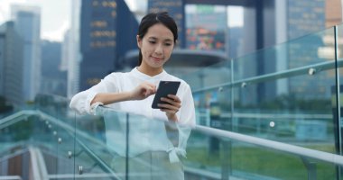 Genç cityscape içinde smartphone kullanan kadın 