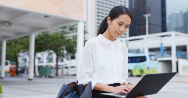 Açık, dizüstü bilgisayar üzerinde çalışan genç iş kadını