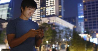 Geceleri cep telefonu kullanan adam