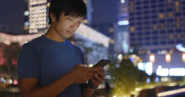 Adam cep telefonuyla şehirde geceleri