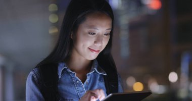 Geceleri tablet bilgisayar kullanan genç kadın