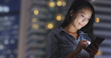 Şehirde akıllı telefon kullanan bir kadın 