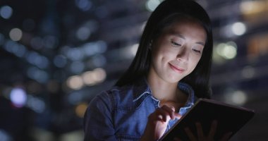 şehirde tablet kullanan kadın