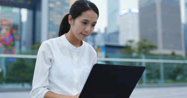 Dizüstü bilgisayarda çalışan Asyalı kadın 