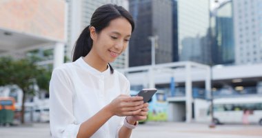 Şehirde cep telefonu kullanan genç bir kadın.