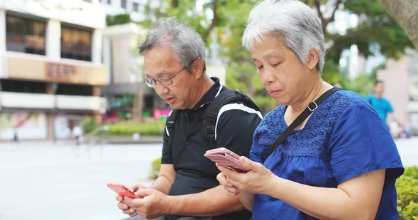 アジアの老夫婦が一緒に携帯電話を使用して — ストック写真