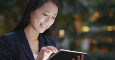 Genç işkadını tablet bilgisayarla şehirde geceleri