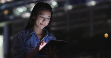 Geceleri tablet bilgisayar kullanan genç kadın