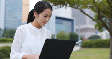 Şehirde dizüstü bilgisayar üzerinde çalışan kadın