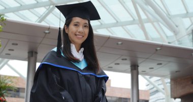 Üniversite kampüsü içinde elbise giyen mezuniyet kadın 