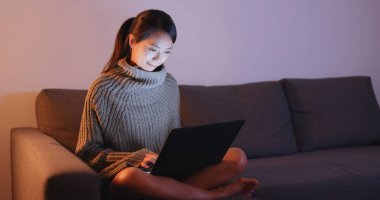 Geceleri dizüstü bilgisayar üzerinde çalışan kadın 