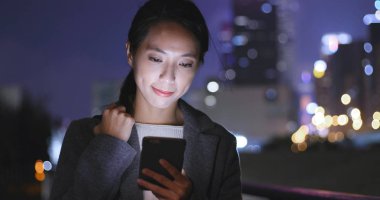 Cep telefonu City gece izlerken kadın 