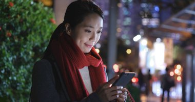 Geceleri cep telefonu kullanan kadın alışveriş 