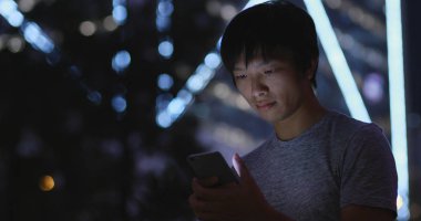 Adam cep telefonuyla şehirde geceleri