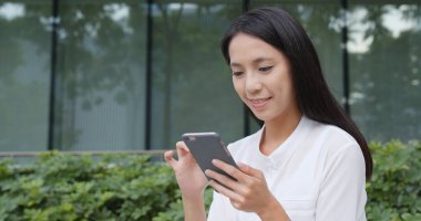 Şehirde cep telefonu kullanan genç bir kadın. 