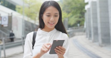 Asyalı kadın şehirde istimal hareket eden telefon