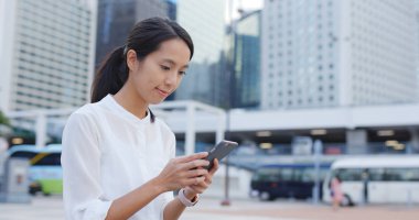 Genç cityscape içinde smartphone kullanan kadın