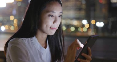 Asyalı kadın şehirde cep telefonu kullanarak 