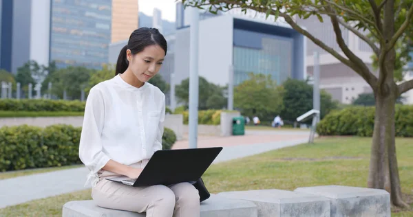 Businesswoman using laptop computer in city