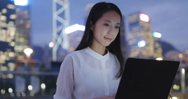 Woman using notebook computer at night