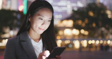 Geceleri cep telefonu kullanarak iş kadını 