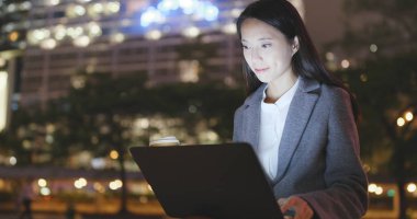 Genç işkadını dizüstü bilgisayarda geceleri çalışır. 