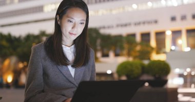 Genç işkadını dizüstü bilgisayarda geceleri çalışır. 