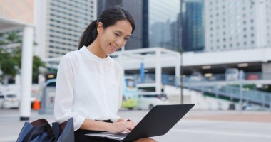 Dizüstü bilgisayar açık, genç işkadını çalışır