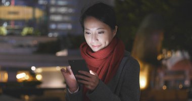 İşkadını Smartphone şehirde geceleri kullanarak. 