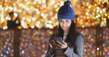 Bokeh arka plan üzerinde akıllı telefon kullanan kadın 