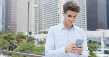 Şehirde cep telefonu kullanan bir adam 