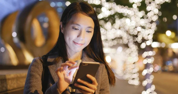 Geceleri cep telefonu kullanan bir kadın. 