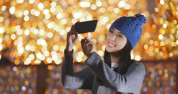 Kadın alarak resmi Noel dekorasyon arka plan üzerinde cep telefonu için 