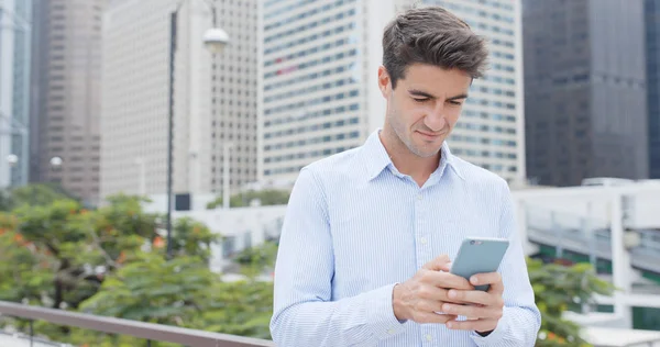 Şehirde cep telefonu kullanan bir adam 