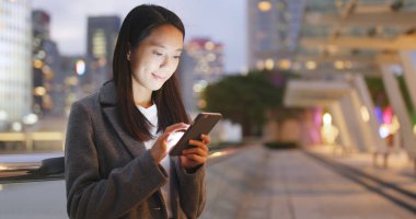 Geceleri Smartphone kullanarak iş kadını 