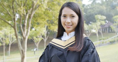 Genç kadın almak mezuniyet yeşil arka plan üzerinde 