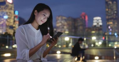 Geceleri cep telefonu kullanan kadın 