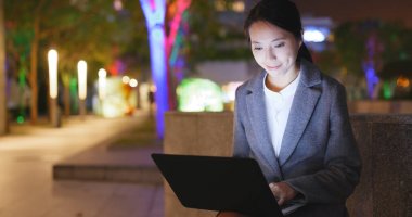 Kadın defter bilgisayar üzerinde geceleri çalışıyor. 